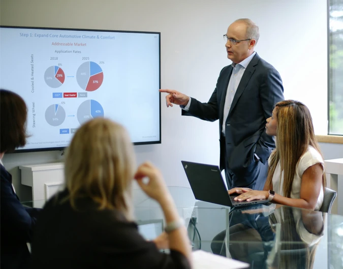 Man standing at a monitor giving a presentation.