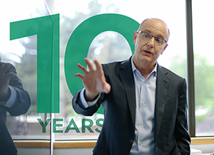 Author Sam Levinson gives a presentation, with graphic text in the background that reads “10 Years.”