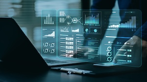 A person working on a laptop with a transparent digital interface hovering above the keyboard, displaying various data visualizations including charts, graphs, and analytics dashboards. The interface features icons for AI, cloud, and data analysis, symbolizing advanced technology and business intelligence. The setting appears modern and professional, with a focus on digital transformation and data-driven decision-making.